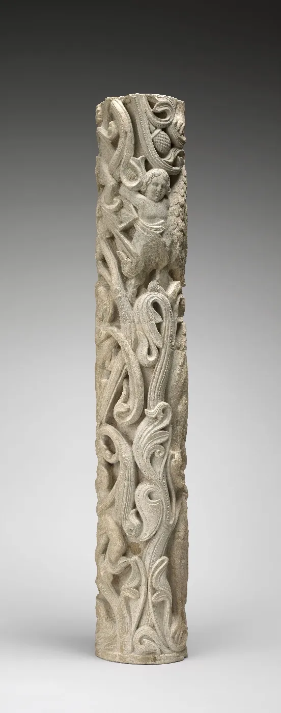 Sculpture en pierre représentant un homme de face dans un entrelac végétal. Vue de face.