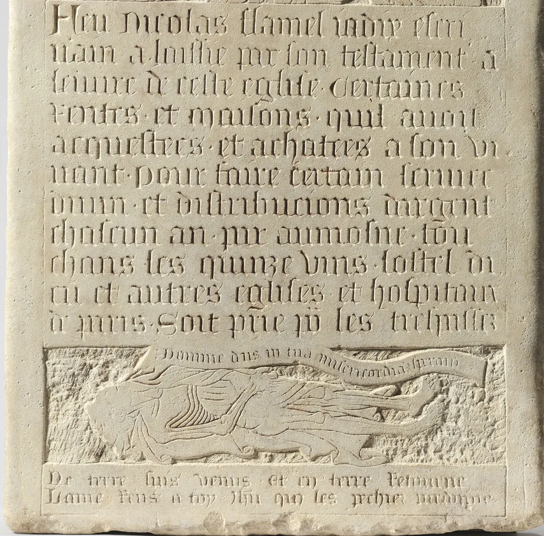 Détail d'une plaque de pierre gravée d’inscriptions au-dessus d’un personnage allongé. Vue de face.