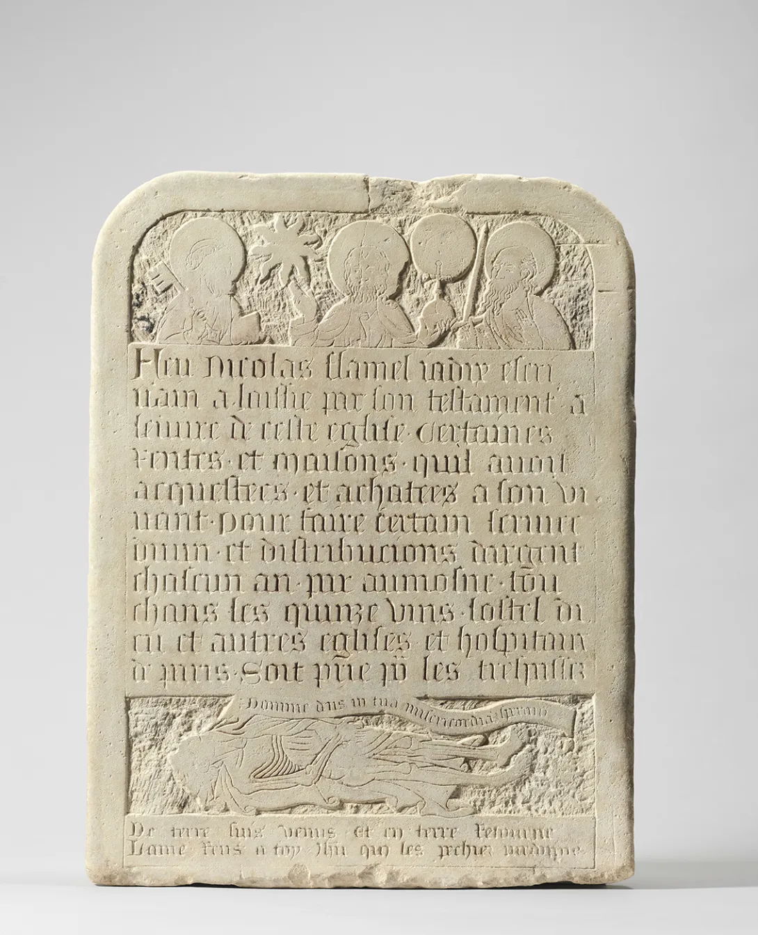 Losa de piedra grabada: inscripciones, figuras con aureola arriba y una figura yacente abajo. Vista frontal.