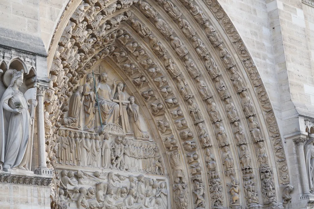 Détail d'un portail occidental de la cathédrale Notre-Dame de Paris. Photographie prise du sol et de trois-quarts. 