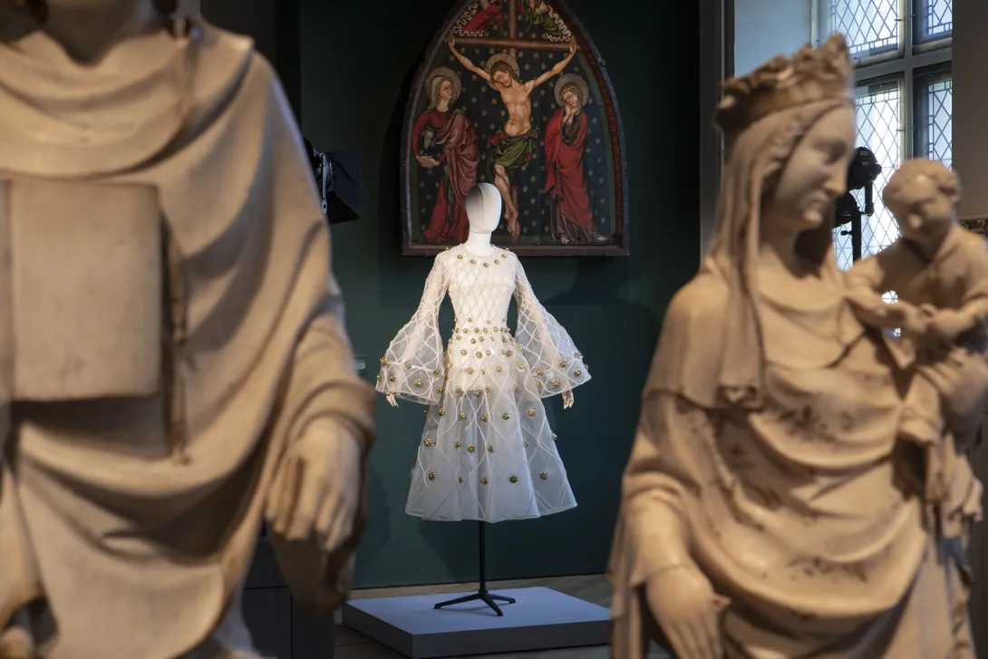Vue d'une salle du musée avec, à l'arrière-plan, une robe blanche posée sur un mannequin