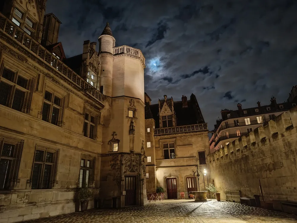 Photographie d'une cour extérieure d'un hôtel médiéval la nuit