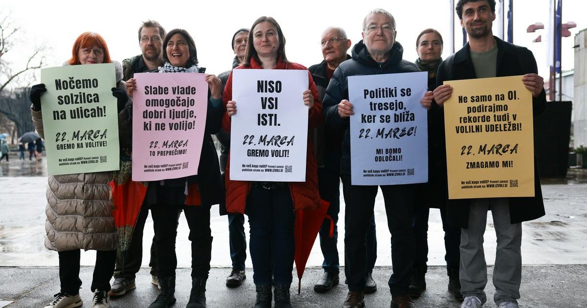 Člani in članice iniciative Glas ljudstva na fotografiji stojijo v skupini in držijo plakate, s katerimi pozivajo k udeležbi na volitvah.