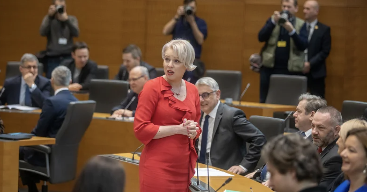 Fotografija poslank in poslancev v DZ, v ospredju Urška Klakočar Zupančič v rdeči obleki.