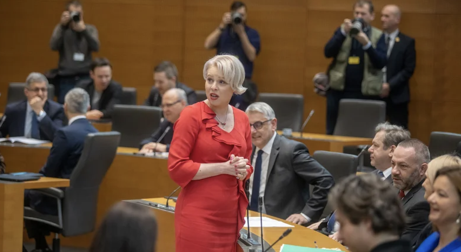 Fotografija poslank in poslancev v DZ, v ospredju Urška Klakočar Zupančič v rdeči obleki.