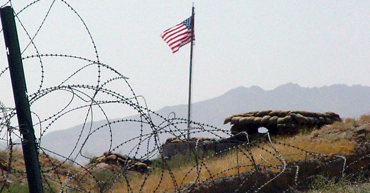 Ameriška zastava vihra za vojaško ograjo v Afganistanu.
