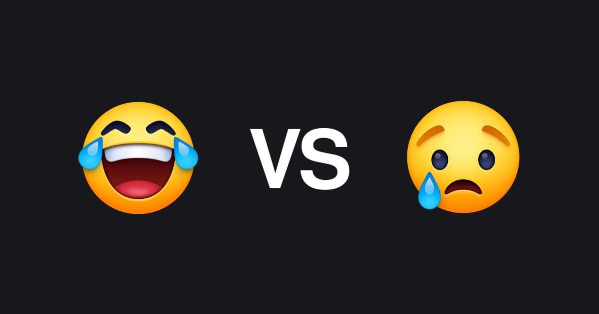 Emotikona za smeh s solzami in jok na črni podlagi, med njima pa beseda VS.