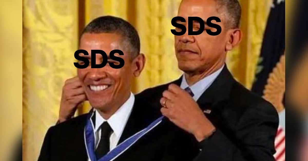 Obama, ki daje medaljo Obami. Na obeh je izpisano SDS.
