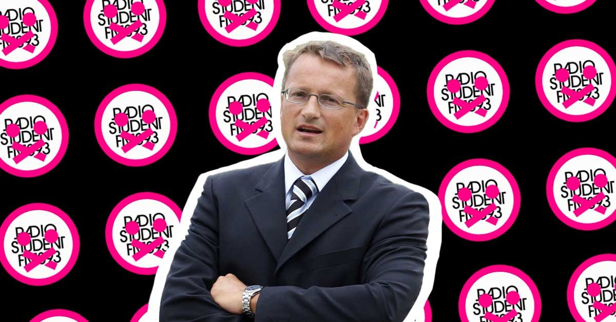 Andrej Klasinc, v ozadju pa beli logotipi Radia Študent na črnem ozadju, ki imajo čez emoji s prelepljenimi usti.