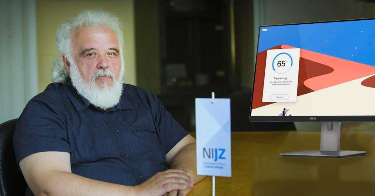Milan Krek za mizo, desno od njega je računalniški ekran z odprto aplikacijo WeTransfer.