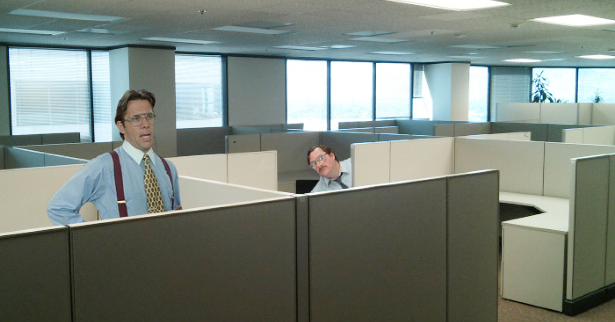 Dva zaposlena, sicer lika iz filma Office Space, v pisarni, sestavljeni iz manjših kabin.
