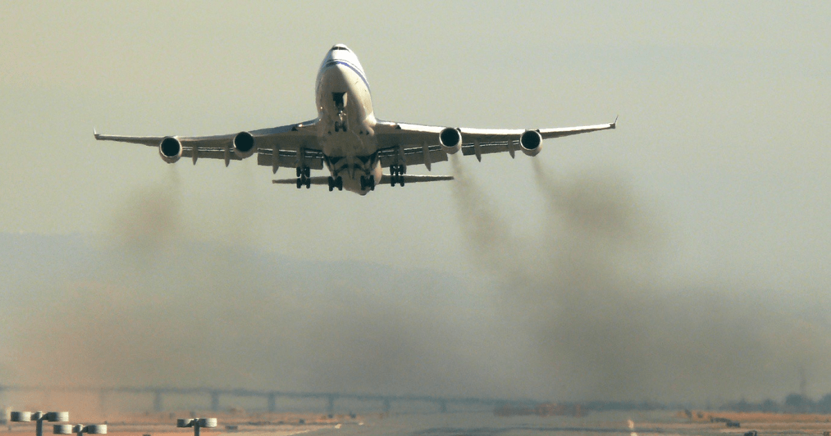 Boeing med vzletanjem, za njim črn oblak emisij