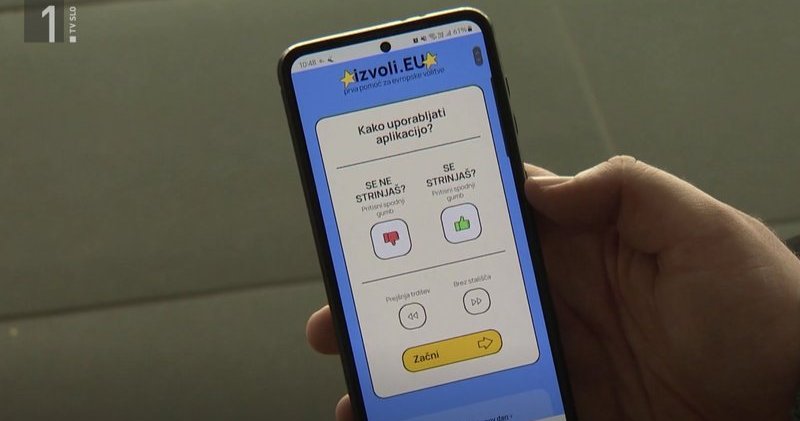 Zajem zaslona iz televizijskega prispevka o Izvoli.eu, na katerem je telefon z odprto aplikacijo Izvoli.eu