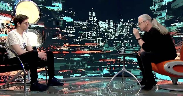 Filip Dobranić in Marcel Štefančič sedita vsak na svojem stolu v televizijskem studiu.