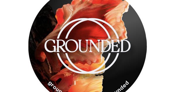 Logotip festivala Grounded, v ozadju napisa je cvet.