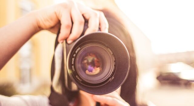 Fotografije osebe, ki drži fotoaparat usmerjen v kamero
