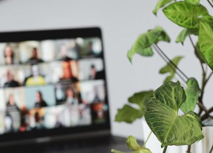un écran d'ordinateur avec une mosaique de visages en réunion sur Zoom