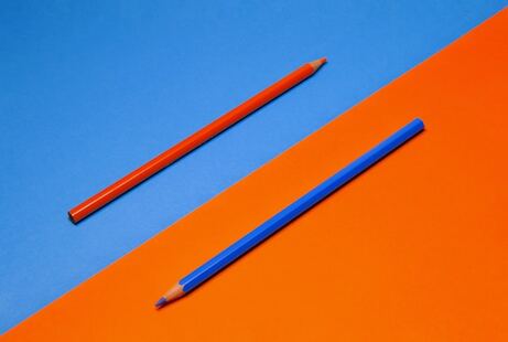 un crayon orange sur fond bleu et un crayon bleu sur fond orange