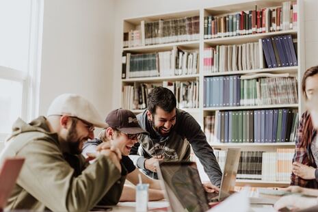 photo de quatre homme autour d'un bureau en train de rire