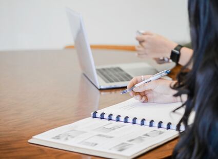 main de femme écrivant sur un cahier ouvert