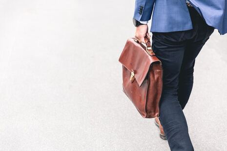 homme marchant dans la rue avec un sac de travail