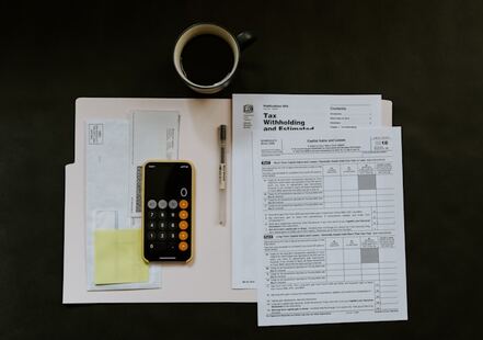 un bureau avec une calculatrice et des fichiers comptables