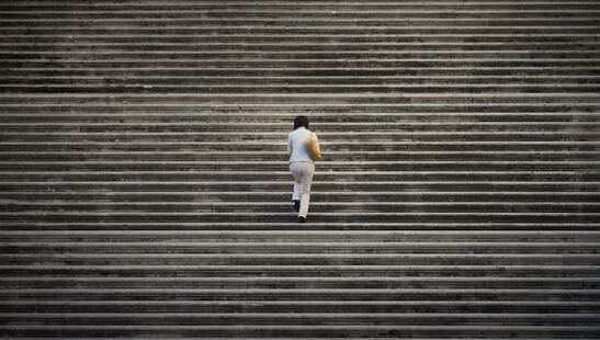 une femme montant des marches sur un très large escalier