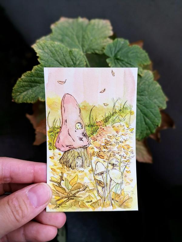 Illustration à l'aquarelle représentant un champignon imaginaire au chapeau rosé, dans lequel vit un petit être de la nature. Le champignon est entouré de feuilles mortes aux couleurs de l'automne.