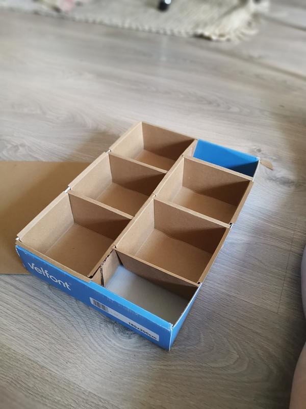 La même boite en carton, posée au sol. On voit bien les 5 espaces dedans qui serviront à contenir les cachets de thés.