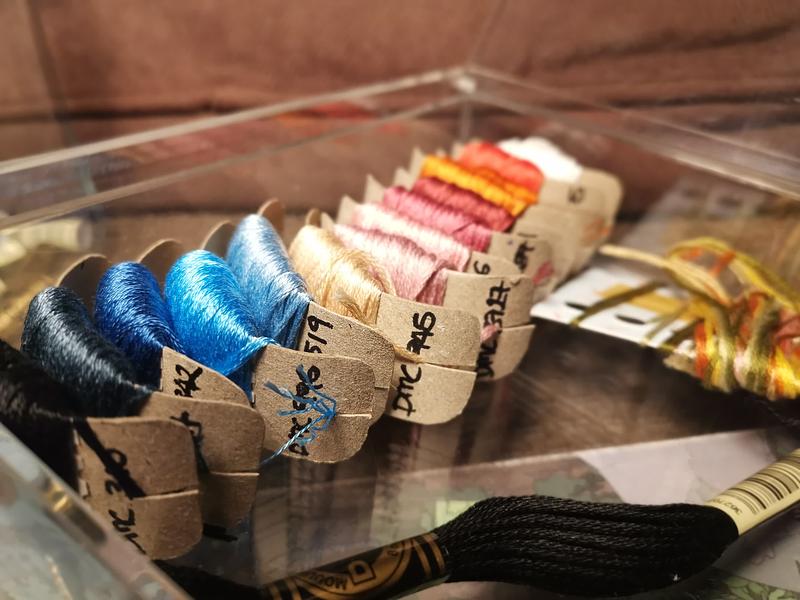 Gros plan sur des fils à broder rangés les uns côté des autres.