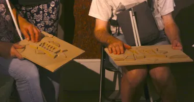 Une groupe de visiteurs écoutent la description de la maquette du Mont-Saint-Michel