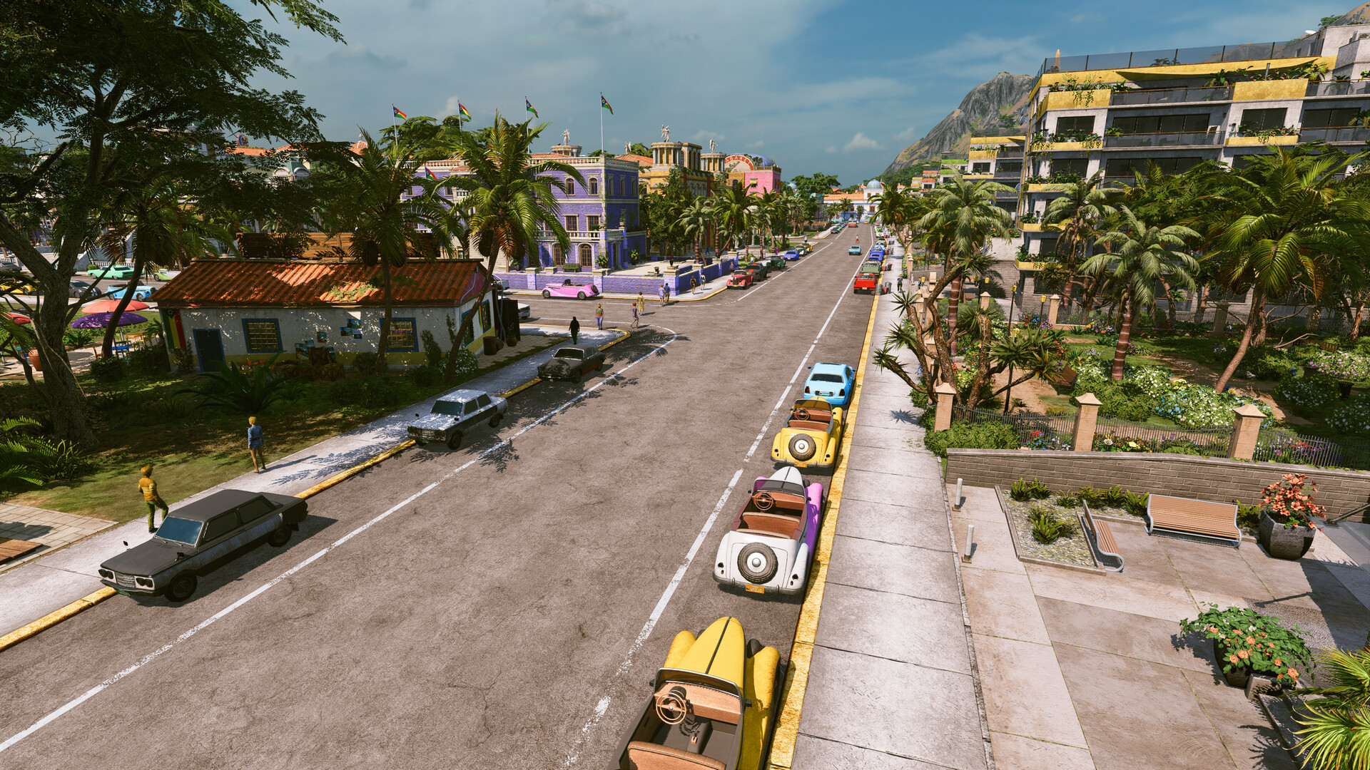 Une avenue de Tropico bordée de palmiers, avec des voitures garées le long du trottoir et des immeubles coloniaux colorés