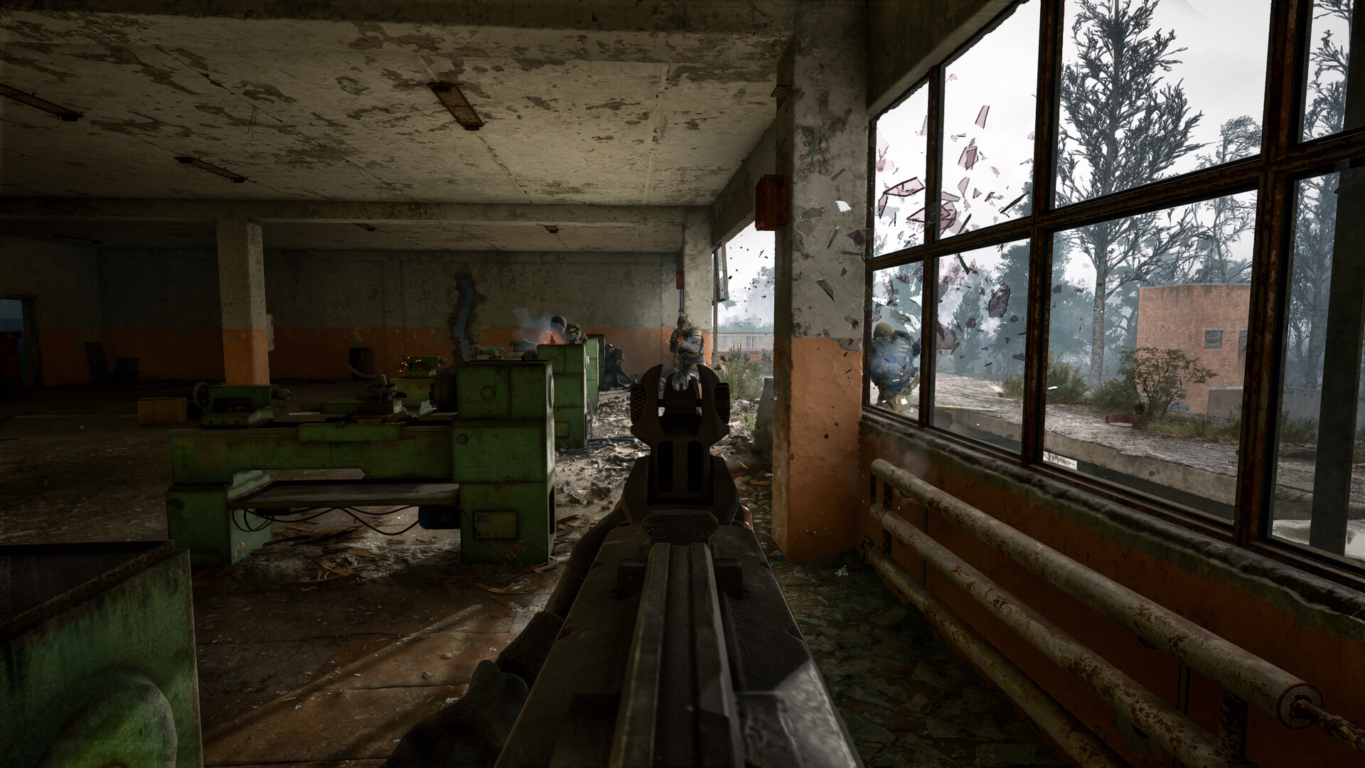 Échange de tirs dans un atelier désaffecté de S.T.A.L.K.E.R. 2, vitres brisées et ennemis en exosquelette à l'extérieur