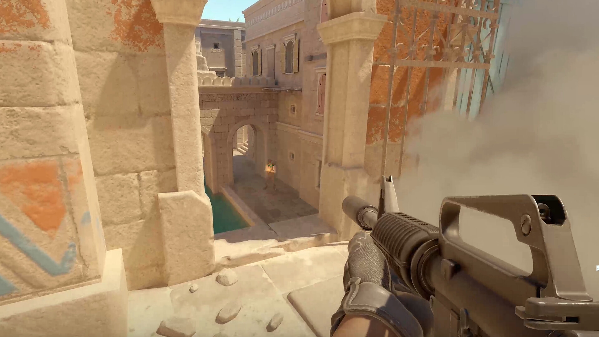 Vue à la première personne d'un joueur de Counter-Strike 2 posté derrière un pilier de pierre, un fumigène se déployant à droite