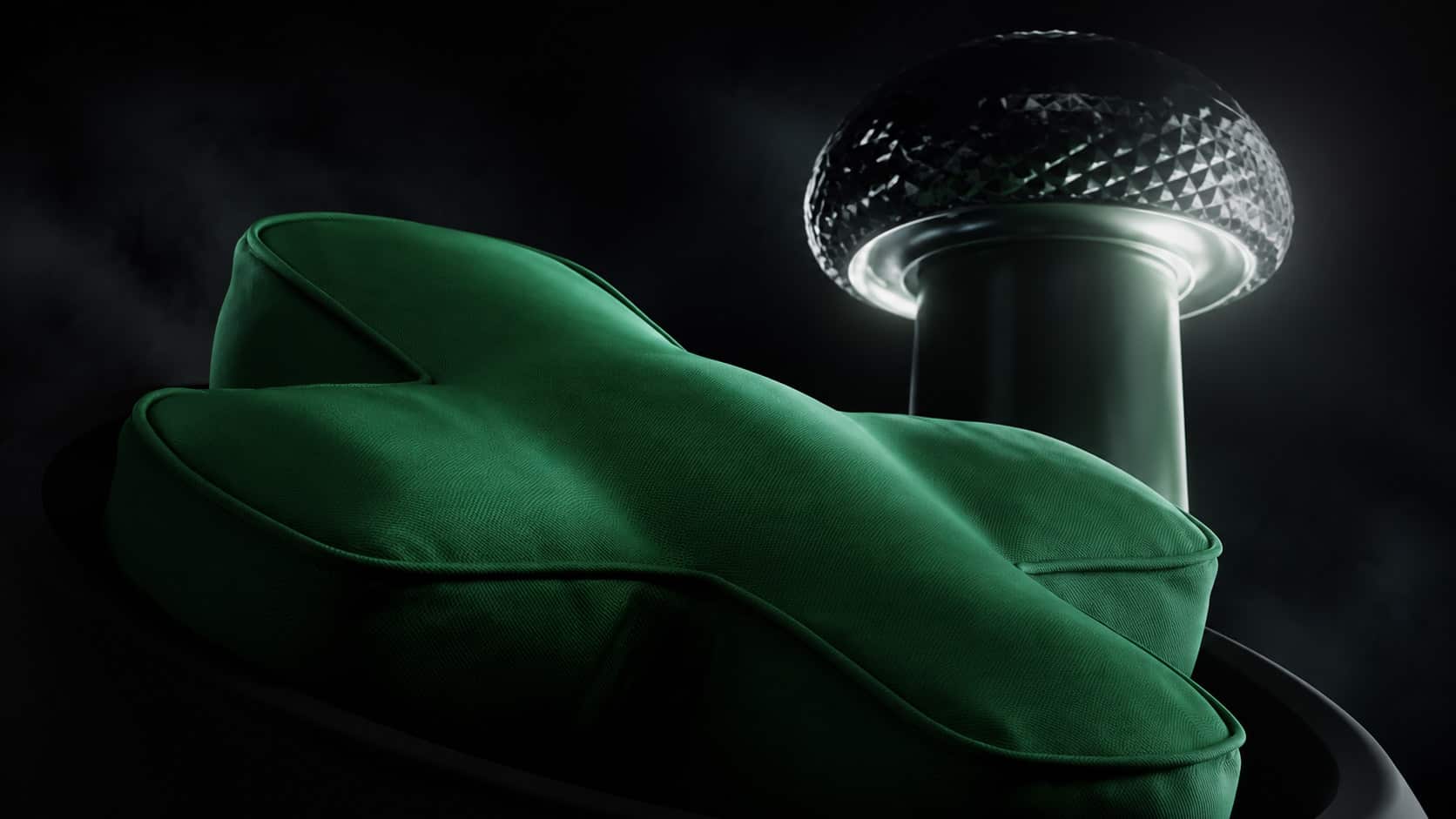 Coussin vert en forme de croix directionnelle de manette Xbox, devant un objet lumineux à silhouette de stick analogique