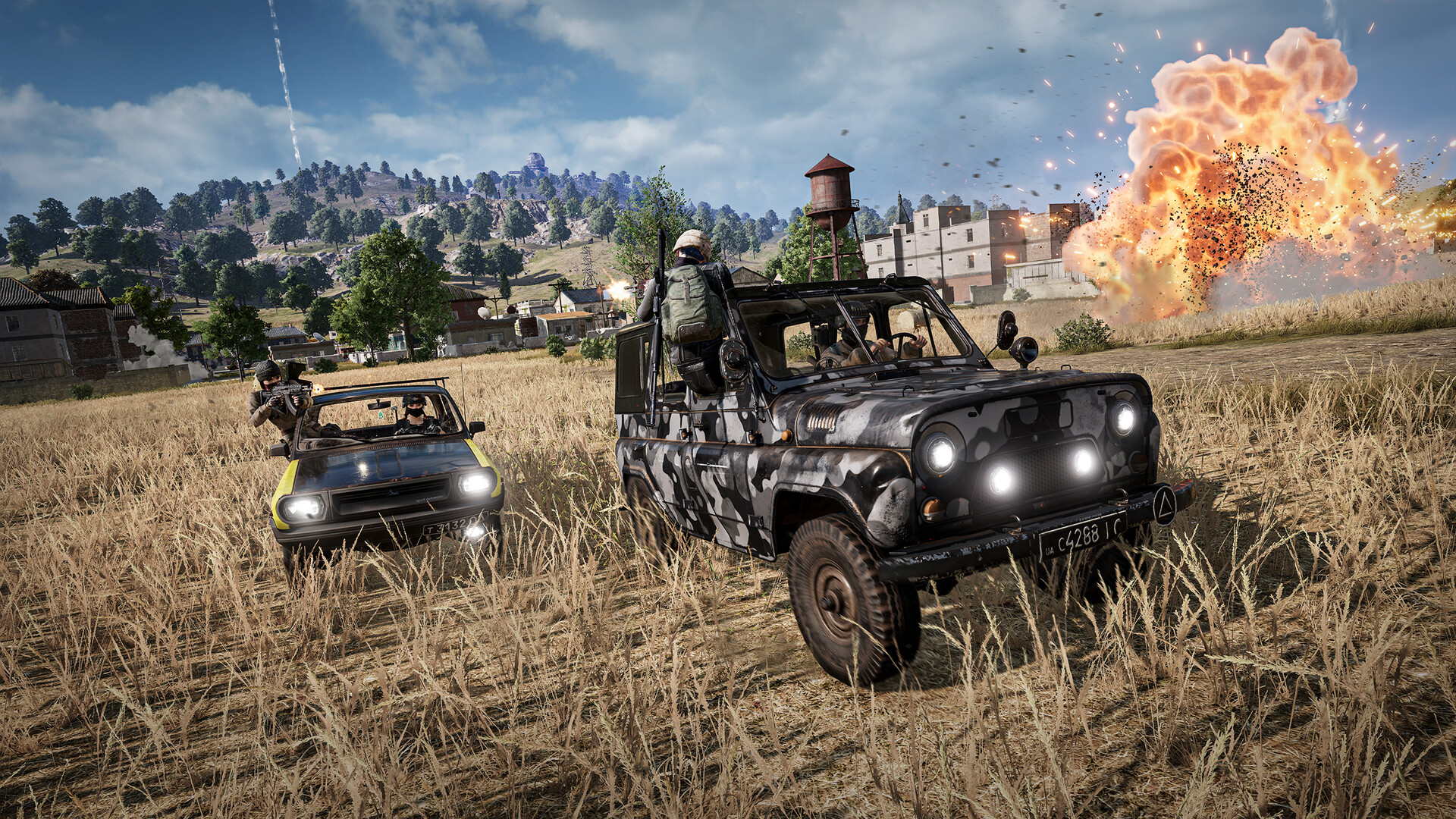 Deux véhicules de PUBG: Battlegrounds roulent dans un champ pendant qu'une explosion éclate sur la droite