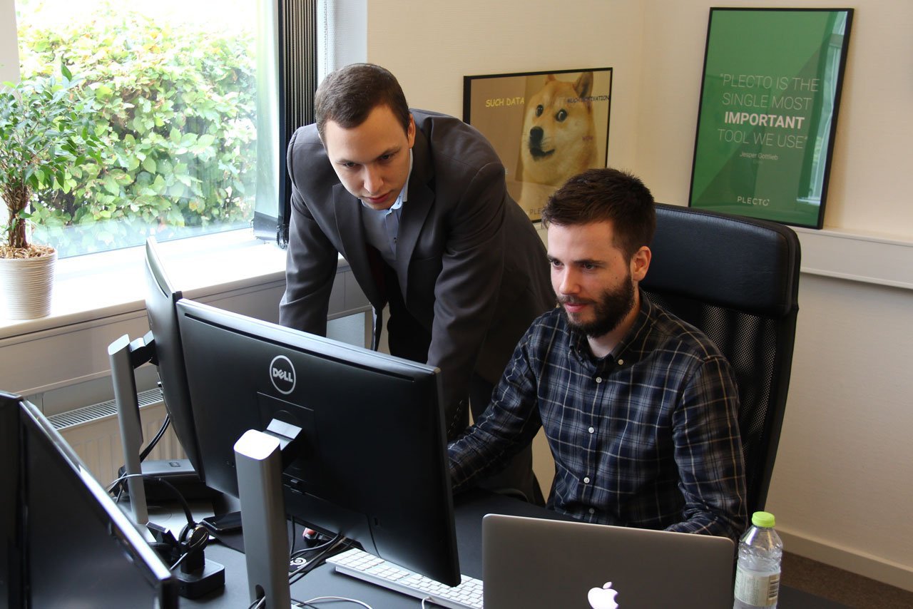 Blog - Kristian and Ales looking at a computer screen in the office