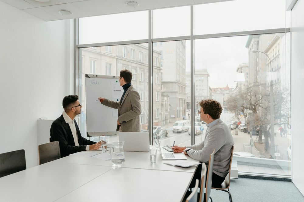 Three professionals engaged in a business meeting in a bright conference room.