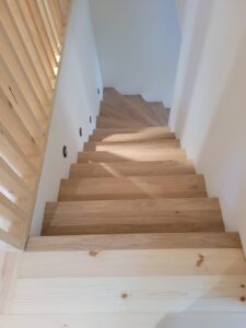 Habillage d'escalier, parquet chêne massif Parqueterie de Bourgogne pour les marches avec ponçage et vitrification du bois sur site puis habillage des contremarches en panneaux à peindre