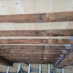 Rénovation d'une grange avec une pose clouée de parquet massif sur poutres existantes sur lambourdes