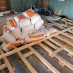 Rénovation d'une grange avec une pose clouée de parquet massif sur poutres existantes sur lambourdes