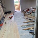 Rénovation d'une grange avec une pose clouée de parquet massif sur poutres existantes sur lambourdes