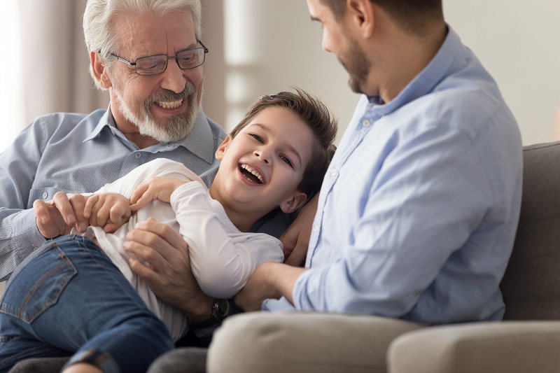 Cheerful grandfather son and grandson having fun at home