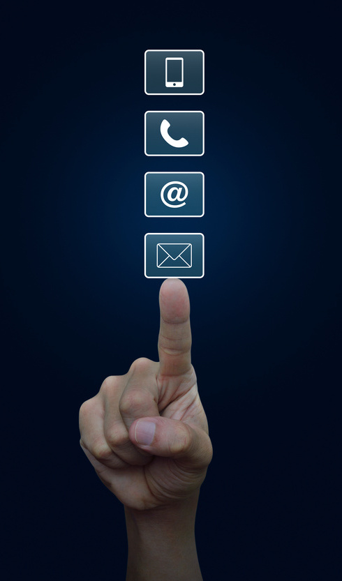 Hand pressing telephone, mobile phone, at and email buttons over