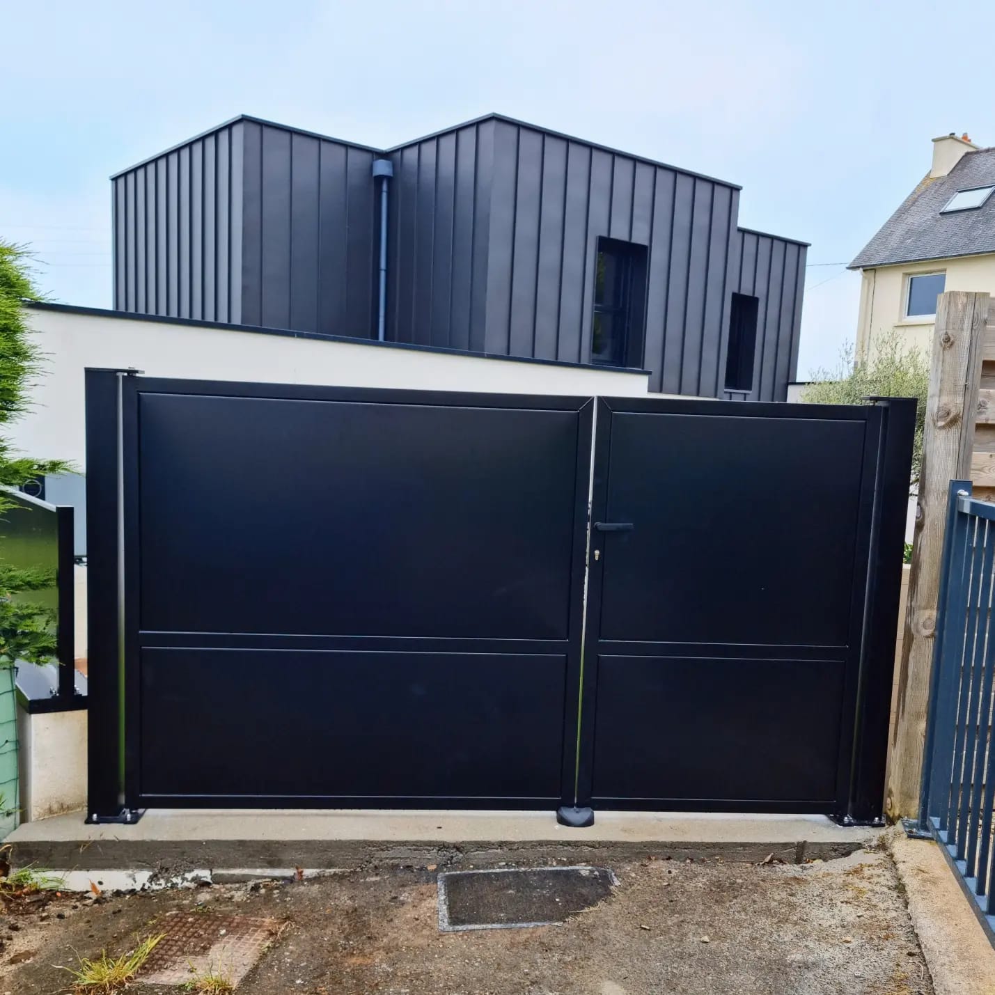 Portail à deux vantaux en inox et parements aluminium