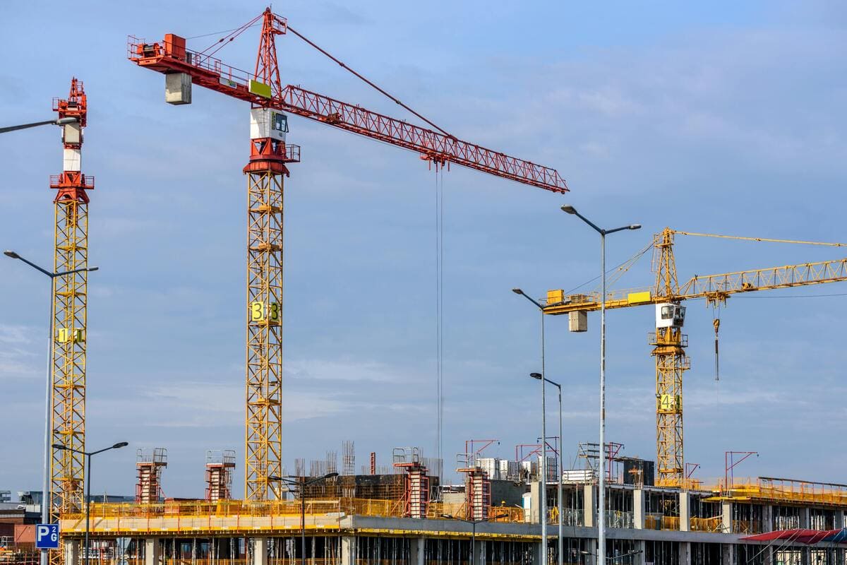 Construction d'un bâtiment, grues devant le ciel bleu