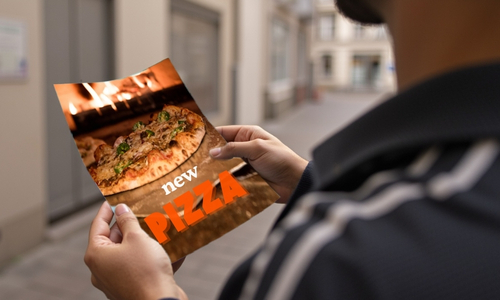 personne lisant un flyer sur l'ouverture d'une nouvelle pizzeria, tract pour annoncer un événement, street marketing